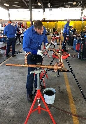 A man focused on welding copper joints